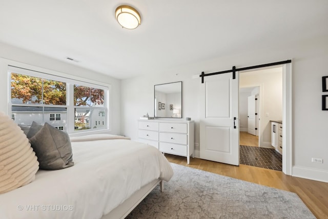 1110 Hickory Dr, Western Springs, IL 60558 - bedroom featuring a barn door, wood finished floors, and baseboards