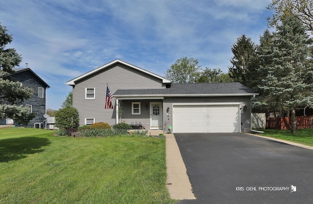 split level home with asphalt driveway and an attached garage