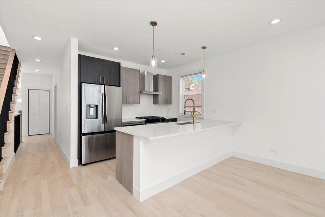 2700 W Jackson Blvd, Chicago, IL 60612 - kitchen with stainless steel refrigerator with ice dispenser, wall chimney exhaust hood, a sink, a peninsula, and light wood finished floors