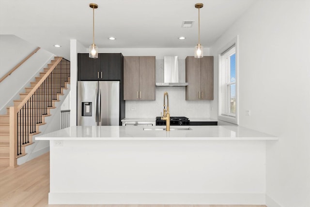 2700 W Jackson Blvd, Chicago, IL 60612 - kitchen featuring wall chimney range hood, stainless steel fridge with ice dispenser, light countertops, tasteful backsplash, and light wood-style floors