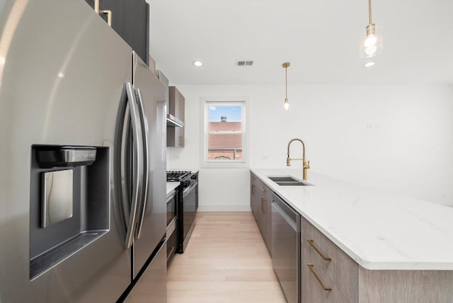 2700 W Jackson Blvd, Chicago, IL 60612 - kitchen with stainless steel appliances, modern cabinets, a sink, a peninsula, and light wood-type flooring