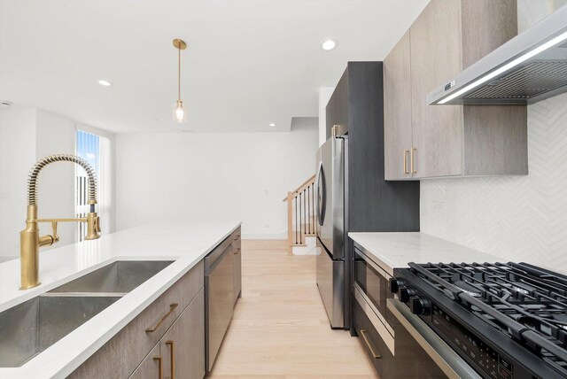 2700 W Jackson Blvd, Chicago, IL 60612 - kitchen featuring ventilation hood, stainless steel appliances, a sink, light wood-style floors, and pendant lighting