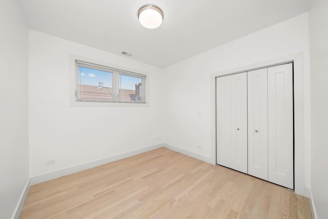 2700 W Jackson Blvd, Chicago, IL 60612 - unfurnished bedroom with light wood-style floors, baseboards, and a closet