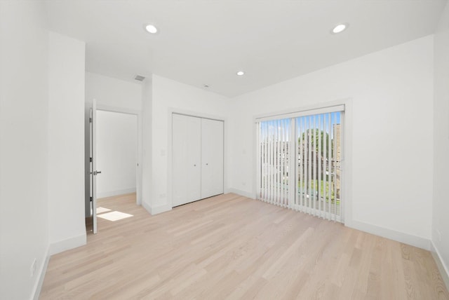 2700 W Jackson Blvd, Chicago, IL 60612 - unfurnished bedroom with light wood-style floors, baseboards, a closet, and recessed lighting