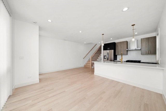 2700 W Jackson Blvd, Chicago, IL 60612 - kitchen with wall chimney range hood, stainless steel fridge with ice dispenser, recessed lighting, light wood-style flooring, and baseboards