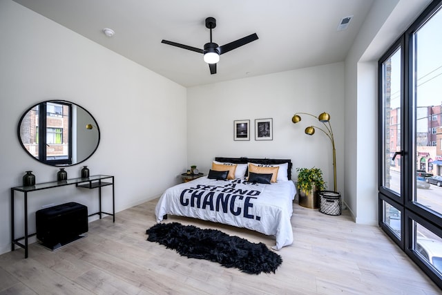 bedroom featuring multiple windows, wood finished floors, and ceiling fan