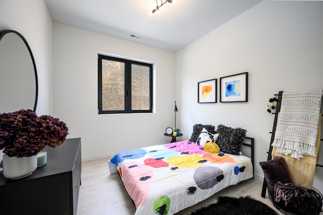 bedroom with light wood-type flooring and baseboards