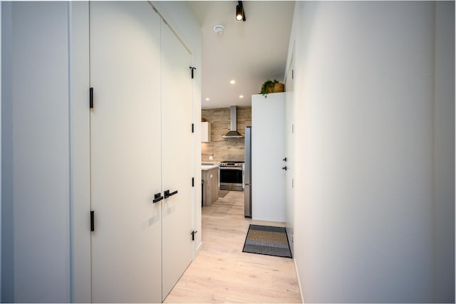 hall with light wood-style floors and recessed lighting