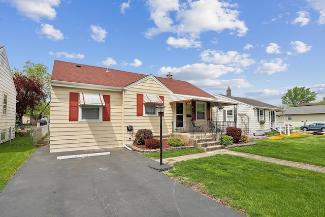 bungalow-style house with a front yard, uncovered parking, and a chimney