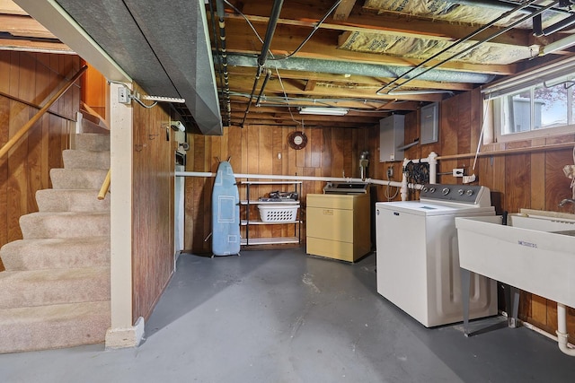 below grade area with wood walls, separate washer and dryer, and stairs