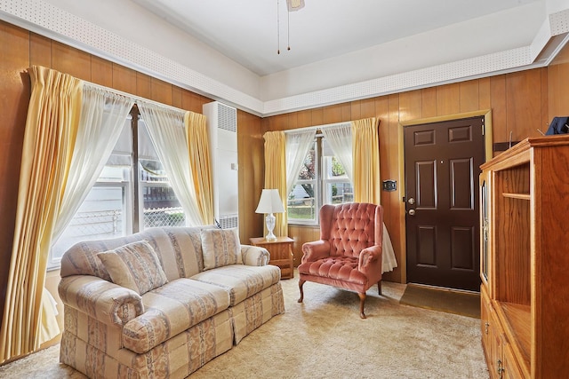 sitting room with light carpet and wooden walls