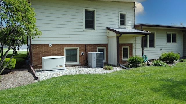 406 E Fine St, Ashkum, IL 60911 - rear view of house featuring central air condition unit, a lawn, and brick siding