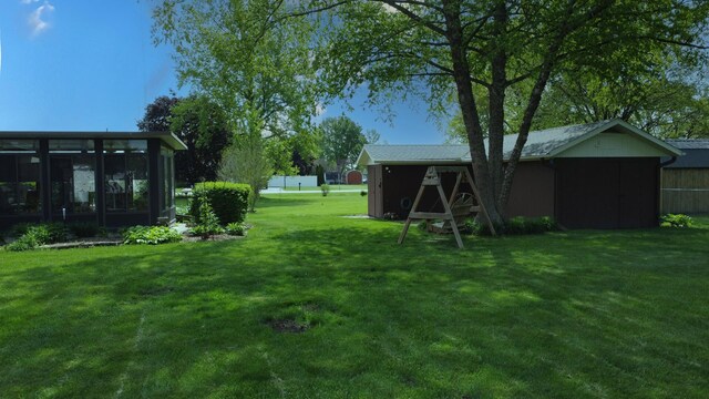 406 E Fine St, Ashkum, IL 60911 - view of grassy yard with a sunroom and an outdoor structure