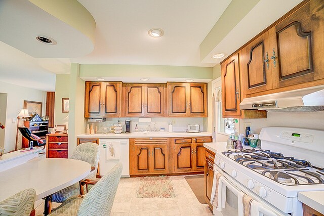 406 E Fine St, Ashkum, IL 60911 - kitchen featuring white appliances, under cabinet range hood, brown cabinetry, light countertops, and recessed lighting