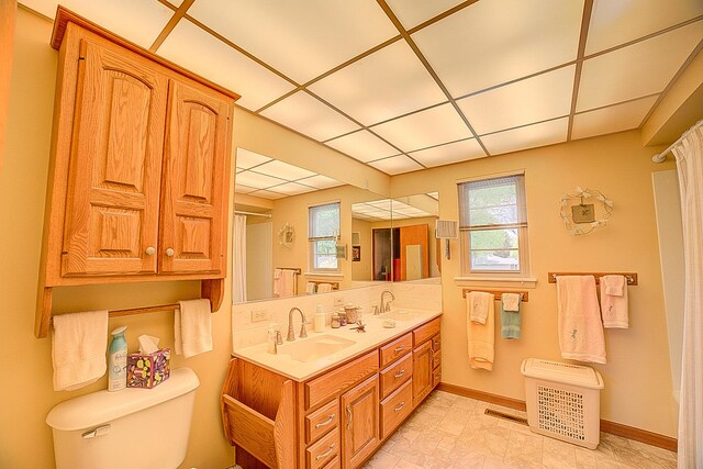 406 E Fine St, Ashkum, IL 60911 - bathroom with toilet, double vanity, plenty of natural light, baseboards, and a drop ceiling