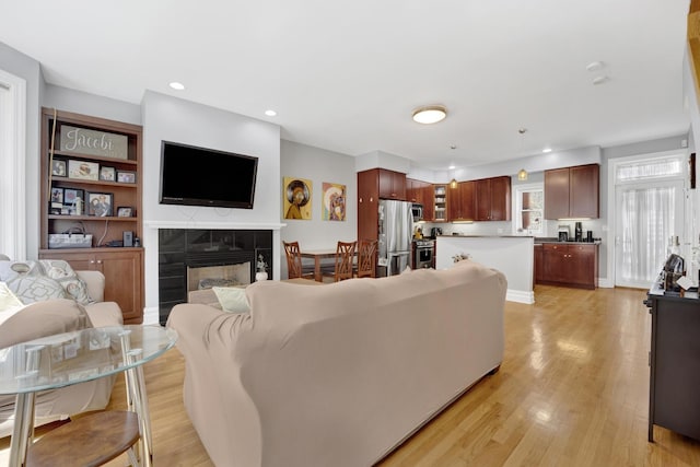 5127 N Damen Ave Unit B, Chicago, IL 60625 - living room featuring light wood-style flooring, a tile fireplace, and recessed lighting