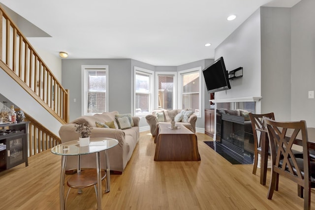 5127 N Damen Ave Unit B, Chicago, IL 60625 - living room featuring light wood-type flooring, a tiled fireplace, stairway, baseboards, and recessed lighting