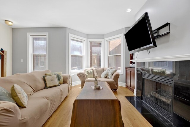 5127 N Damen Ave Unit B, Chicago, IL 60625 - living room featuring a tiled fireplace, light wood finished floors, baseboards, and recessed lighting