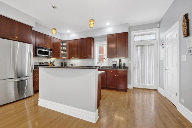 5127 N Damen Ave Unit B, Chicago, IL 60625 - kitchen featuring stainless steel appliances, light wood finished floors, pendant lighting, glass insert cabinets, and recessed lighting