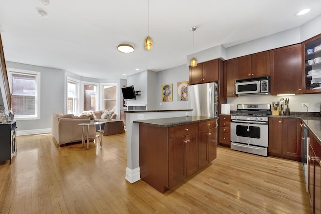 5127 N Damen Ave Unit B, Chicago, IL 60625 - kitchen featuring appliances with stainless steel finishes, dark countertops, light wood-style floors, glass insert cabinets, and recessed lighting