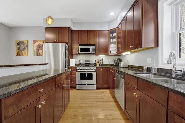 5127 N Damen Ave Unit B, Chicago, IL 60625 - kitchen featuring stainless steel appliances, a sink, light wood finished floors, hanging light fixtures, and dark stone countertops