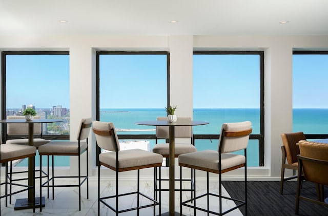 dining space with marble finish floors and a water view