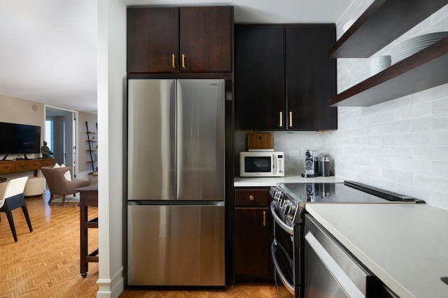 kitchen with appliances with stainless steel finishes, light countertops, dark brown cabinetry, and wall chimney exhaust hood