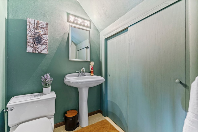 10632 Ventura Blvd, Machesney Park, IL 61115 - bathroom with lofted ceiling, toilet, and baseboards