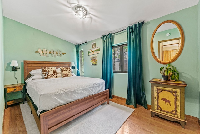 10632 Ventura Blvd, Machesney Park, IL 61115 - bedroom featuring wood finished floors, vaulted ceiling, and baseboards