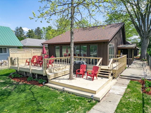 10632 Ventura Blvd, Machesney Park, IL 61115 - back of property with board and batten siding, a deck, a lawn, and a shingled roof