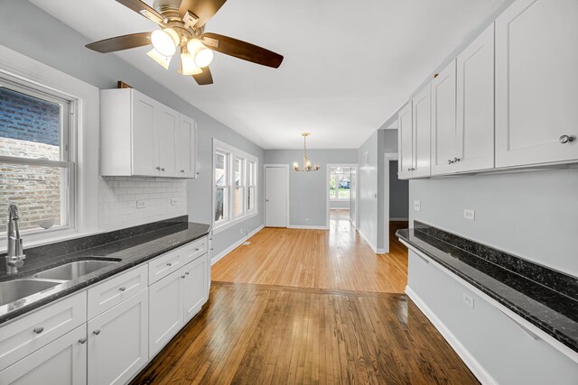 7316 S Woodlawn Ave, Chicago, IL 60619 - kitchen with a chandelier, hardwood / wood-style floors, white cabinetry, and baseboards