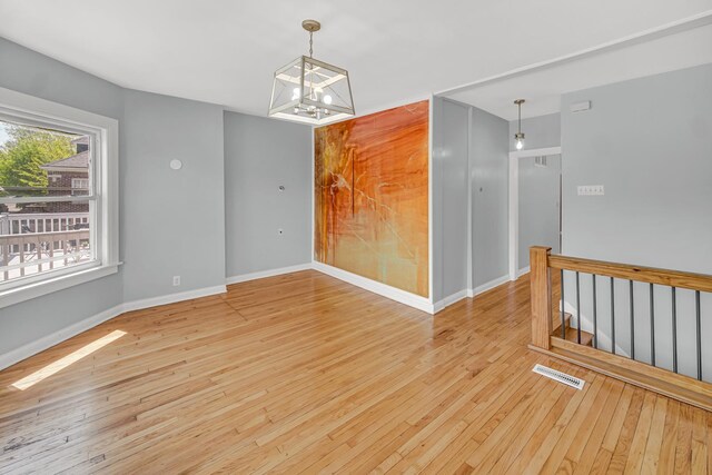 7316 S Woodlawn Ave, Chicago, IL 60619 - spare room featuring hardwood / wood-style flooring, a chandelier, and baseboards