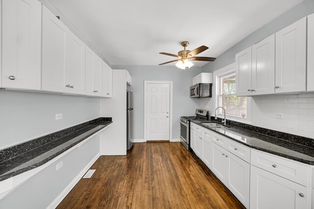 7316 S Woodlawn Ave, Chicago, IL 60619 - kitchen featuring appliances with stainless steel finishes, a sink, baseboards, a ceiling fan, and dark stone counters