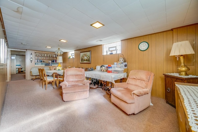 carpeted living area with wood walls