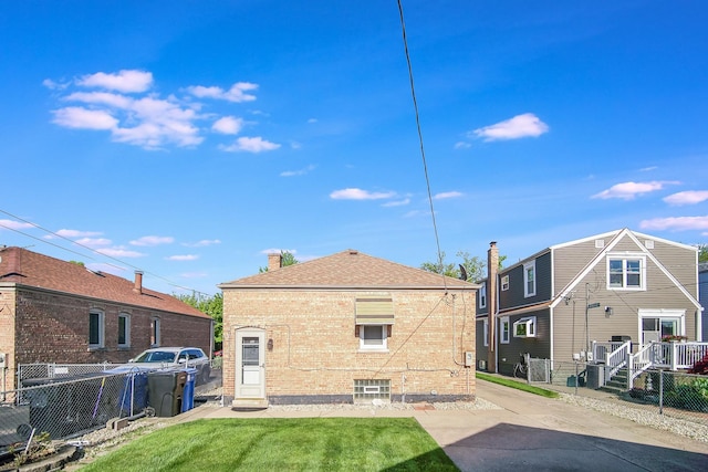 back of house with brick siding and fence