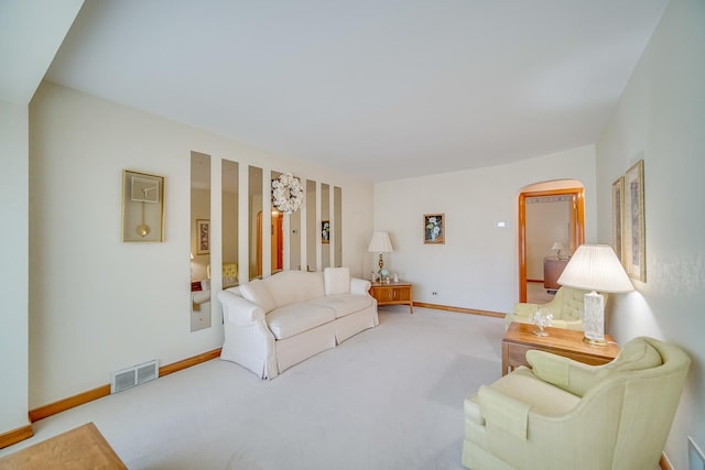living room with arched walkways, carpet floors, and baseboards