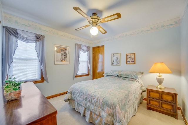 bedroom featuring light carpet, baseboards, and ceiling fan