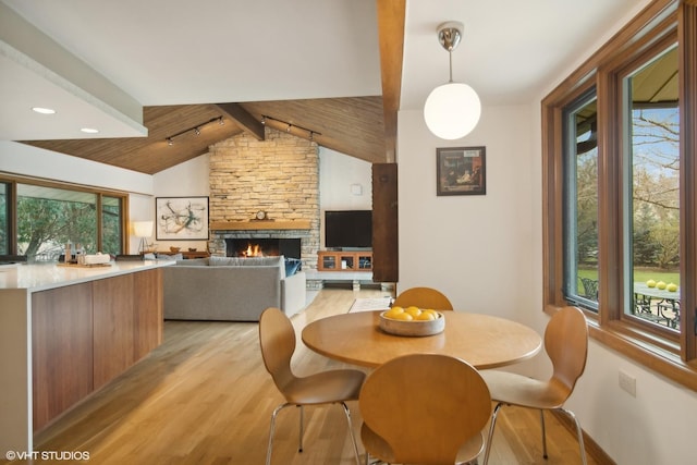 dining area with light wood-style floors, plenty of natural light, a fireplace, and recessed lighting