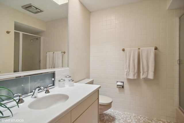 full bath with an enclosed shower, toilet, vanity, and tile patterned floors