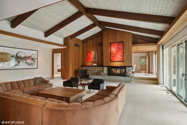 living room featuring carpet flooring, wooden walls, and a glass covered fireplace