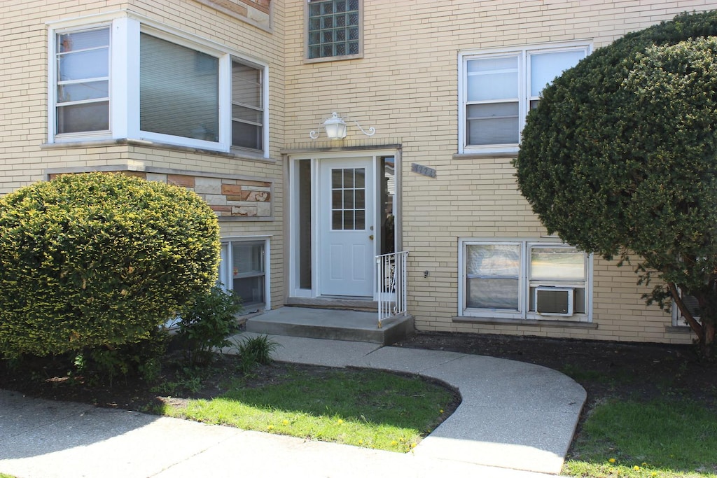 view of exterior entry featuring brick siding