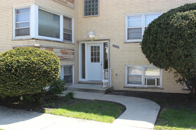 view of exterior entry featuring brick siding