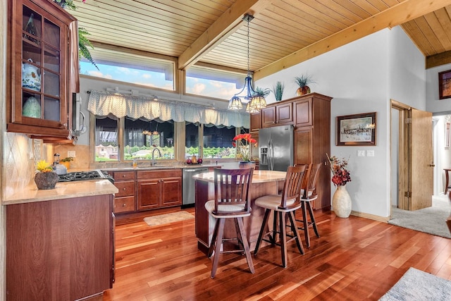 347 Park Dr, Palatine, IL 60067 - kitchen featuring appliances with stainless steel finishes, wooden ceiling with exposed beams, light wood-style floors, a breakfast bar area, and a center island