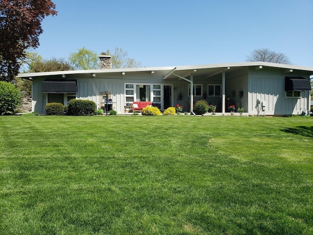 347 Park Dr, Palatine, IL 60067 - rear view of house with board and batten siding, a chimney, and a yard