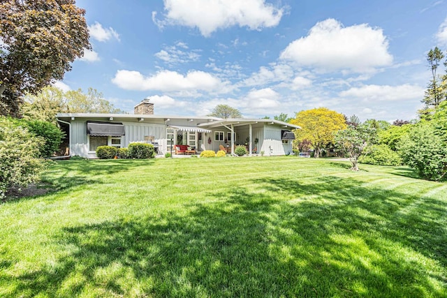 347 Park Dr, Palatine, IL 60067 - rear view of property featuring a chimney, board and batten siding, and a yard