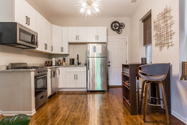 1335 N Greenview Ave Unit 1F, Chicago, IL 60642 - kitchen with stainless steel appliances, white cabinets, dark wood-style flooring, a sink, and light stone counters