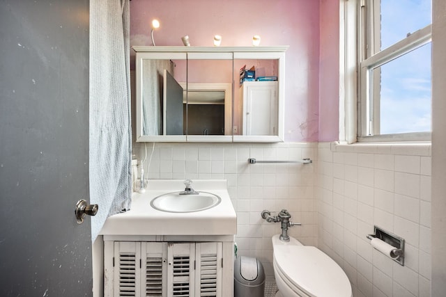 5000 S Cornell Ave Unit 21B, Chicago, IL 60615 - bathroom featuring toilet, vanity, tile walls, and decorative backsplash