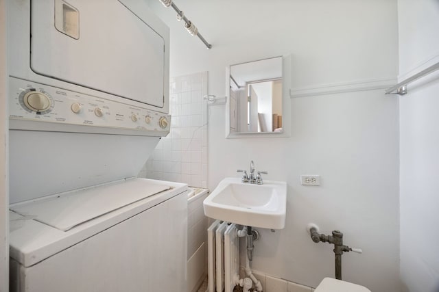 5000 S Cornell Ave Unit 21B, Chicago, IL 60615 - half bath with stacked washer / dryer, a sink, tile walls, and radiator heating unit