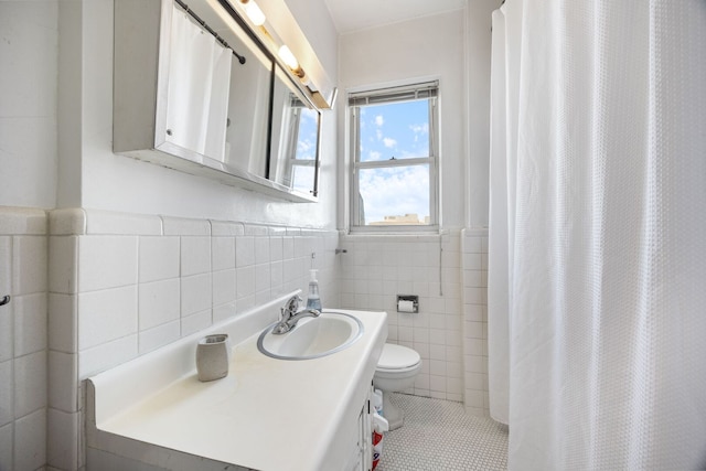 5000 S Cornell Ave Unit 21B, Chicago, IL 60615 - bathroom with tile walls, toilet, tile patterned floors, a wainscoted wall, and a shower with curtain