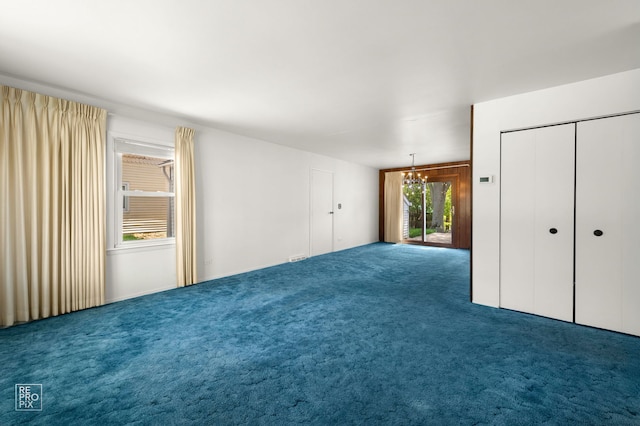 unfurnished bedroom featuring carpet floors, a chandelier, and access to exterior